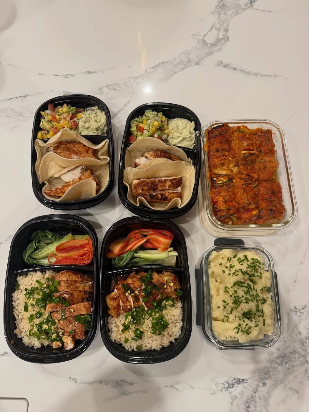 A week of portioned, fully cooked meals in containers, ready to reheat